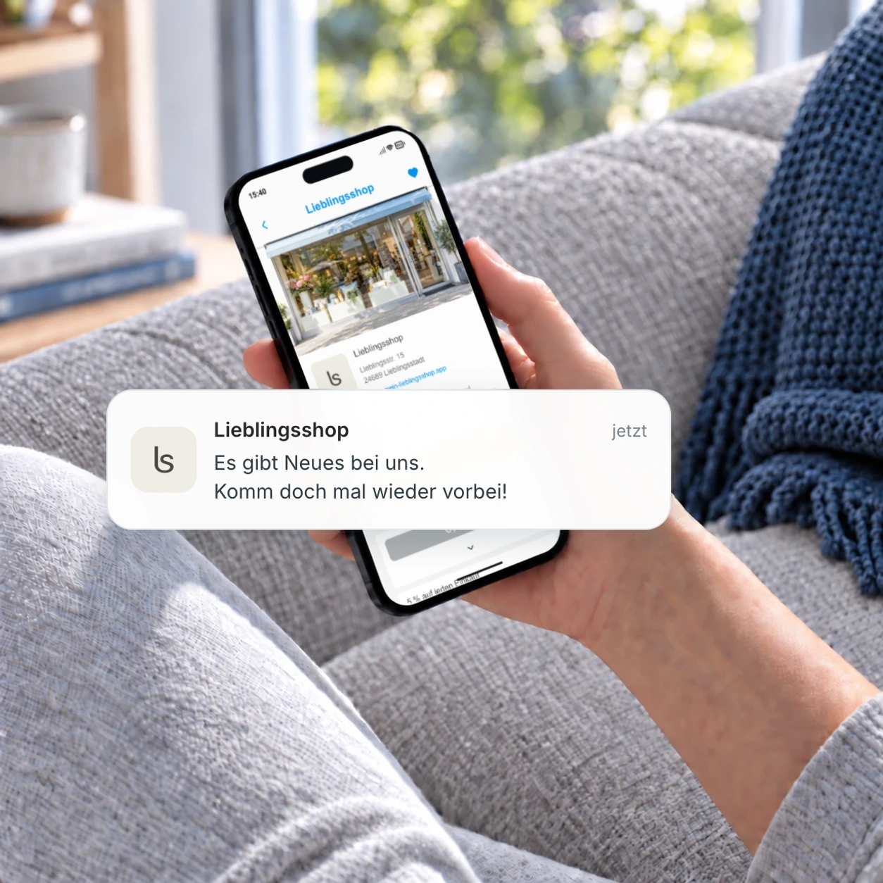 Eine Hand hält zu Hause ein Smartphone mit der Shopfriend-Kunden-App